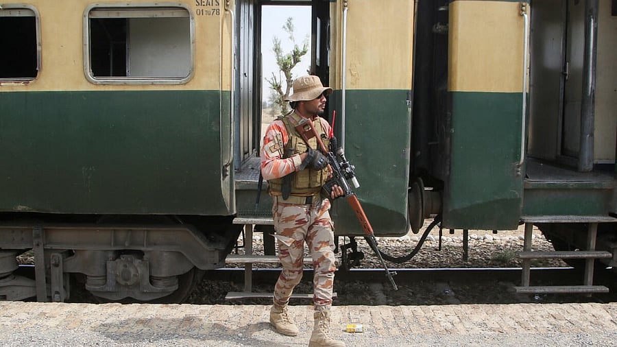 <div class="paragraphs"><p>A Pakistan Army soldier stands guard next to a rescue train, after the attack on a train by separatist militants in Balochistan.</p></div>