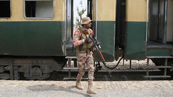 <div class="paragraphs"><p>A Pakistan Army soldier stands guard next to a rescue train, after the attack on a train by separatist militants in Bolan, at the railway station in Mushkaf</p></div>