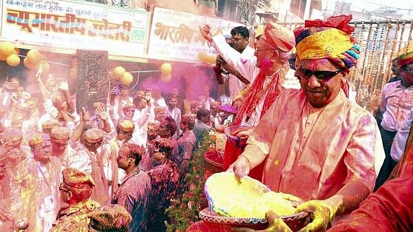 <div class="paragraphs"><p>Uttar Pradesh Chief Minister Yogi Adityanath hurls coloured powder on people during a procession on the occasion of Holi, in Gorakhpur.</p></div>