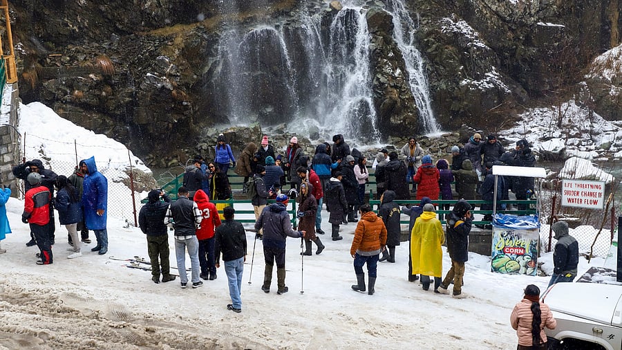 <div class="paragraphs"><p>Tourists and locals visit the waterfall at Drung after fresh snowfall in Tangmarg, in Baramulla district of north Kashmir, Saturday, March 15, 2025.</p></div>