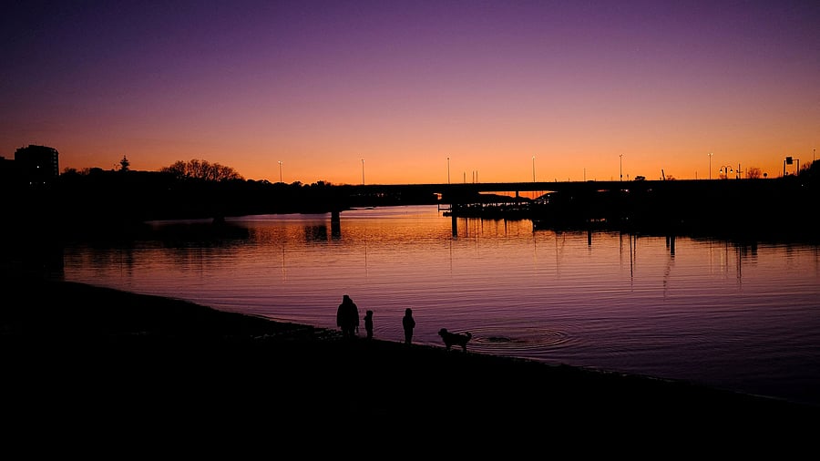 <div class="paragraphs"><p>A family and their dog enjoy a beach during sunset in Vigo, Spain March 15, 2025.</p></div>