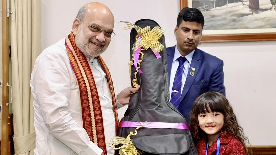 <div class="paragraphs"><p>Union Home Minister Amit Shah gifts a guitar to Mizoram's wonder kid Esther Lalduhawmi Hnamte, in Aizawl.</p></div>