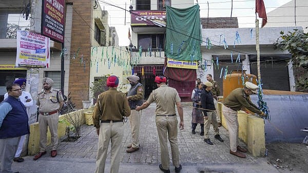 <div class="paragraphs"><p>Police personnel stand guard in front of a temple after an alleged blast here, in Amritsar's Khandwala area, Saturday, March 15, 2025.</p></div>