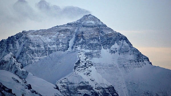 <div class="paragraphs"><p>Wind blows snow off the summit at dusk of the world's highest mountain Mount Everest.</p></div>