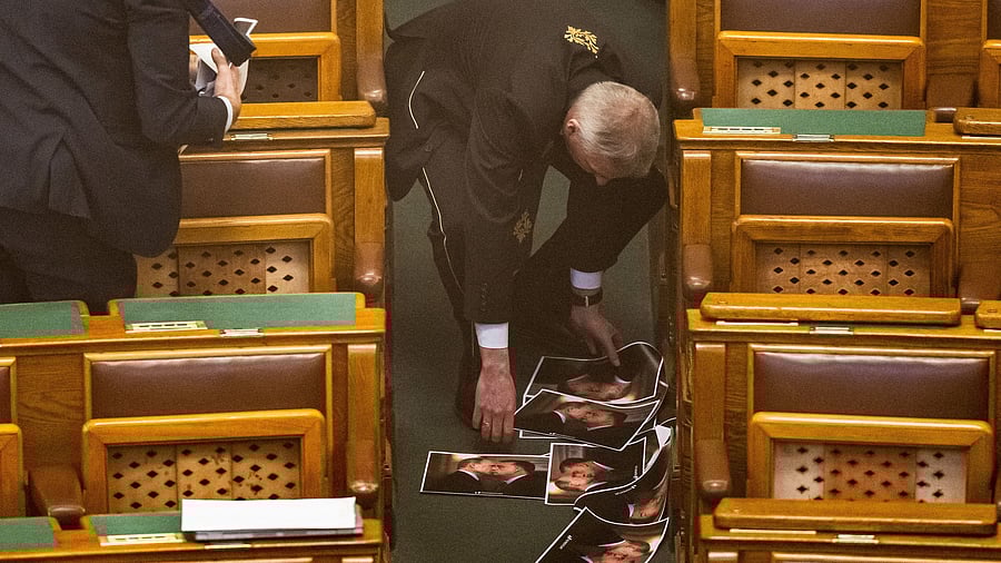 <div class="paragraphs"><p>Parliament staff collect generated images depicting Hungarian Prime Minister Viktor Orban and Russian President Vladimir Putin kissing, which were thrown on the floor by the opposition in protest against a bill that would ban the Pride march by LGBTQ+ communities and impose fines on organizers and people attending the event in Budapest, Hungary, March 18, 2025. </p></div>