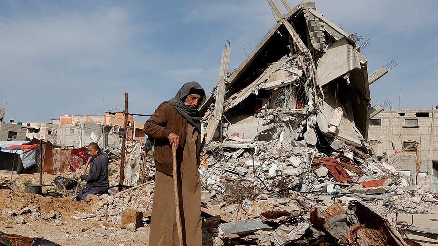 <div class="paragraphs"><p>A Palestinian man walks near the rubble of houses destroyed during the Israeli offensive</p></div>