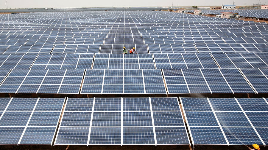 <div class="paragraphs"><p>FILE PHOTO: Workers install photovoltaic solar panels at the Gujarat solar park under construction in Charanka village in Patan district of the western Indian state of Gujarat, India, April 14, 2012. </p></div>