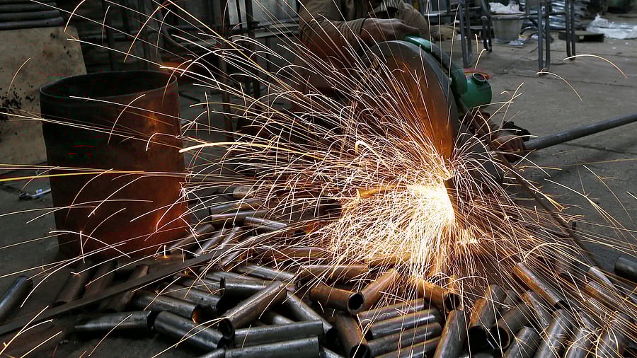 <div class="paragraphs"><p>A worker cuts a metal pipe inside a steel furniture production factory </p></div>