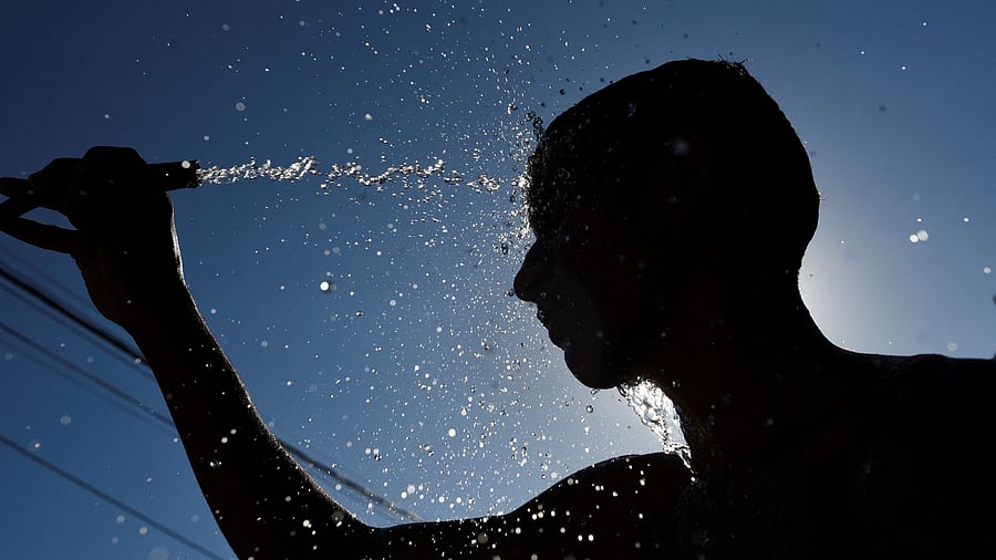 <div class="paragraphs"><p>A man cools himself with a hose on the street during a heat wave. Representative image</p></div>