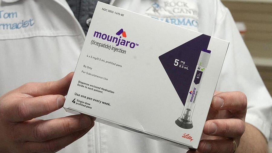 <div class="paragraphs"><p>A pharmacist displays a box of Mounjaro</p></div>