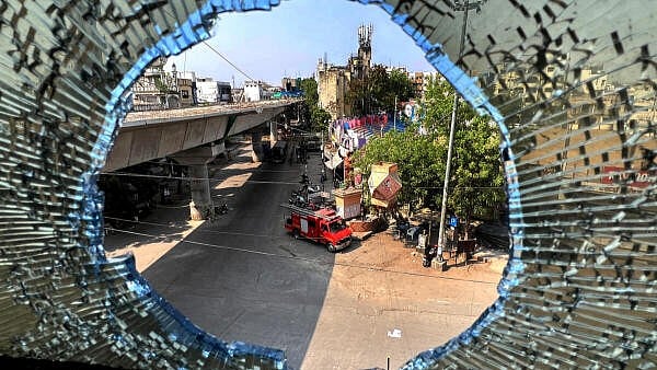 <div class="paragraphs"><p>A deserted street seen through a broken glass pane during the third day of curfew, days after violence broke out following an agitation by a right-wing group demanding removal of Aurangzeb's tomb, in Nagpur.</p></div>