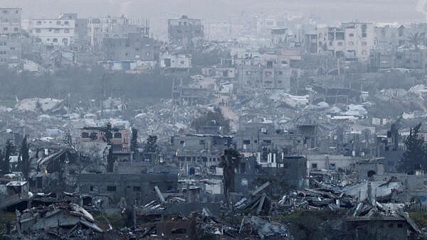 <div class="paragraphs"><p>People walk among destroyed buildings in Gaza, as viewed from the Israel-Gaza border, March 20, 2025.</p></div>