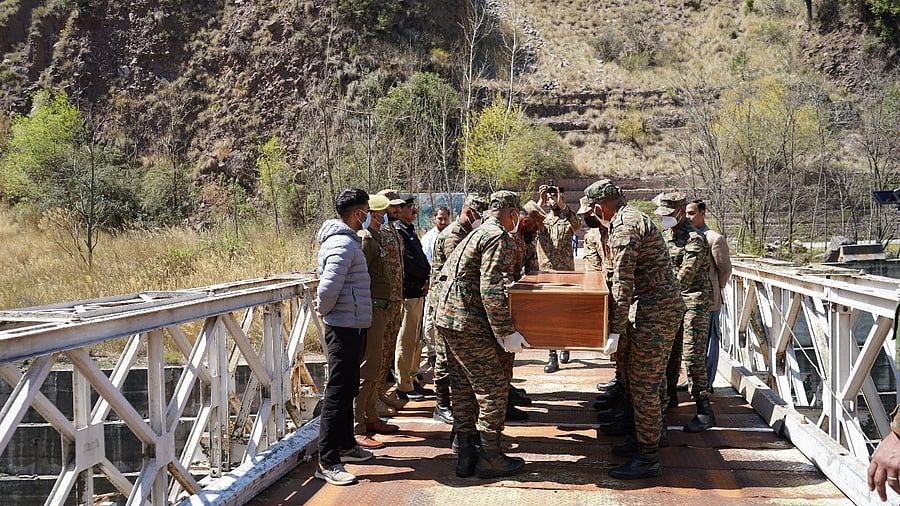 <div class="paragraphs"><p>Indian Army officials facilitate the return of the mortal remains of two missing youths from Pakistan-Occupied Kashmir (POJK), at Uri in Baramulla on Saturday</p></div>