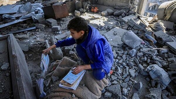 <div class="paragraphs"><p>A Palestinian boy collects books at the site of an Israeli strike on a house, in Gaza City, March 24, 2025.</p></div>