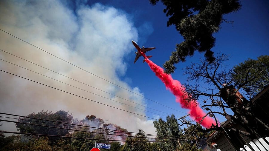 <div class="paragraphs"><p> A plane makes a drop as smoke billows from the Palisades Fire at the Mandeville Canyon, in Los Angeles</p></div>
