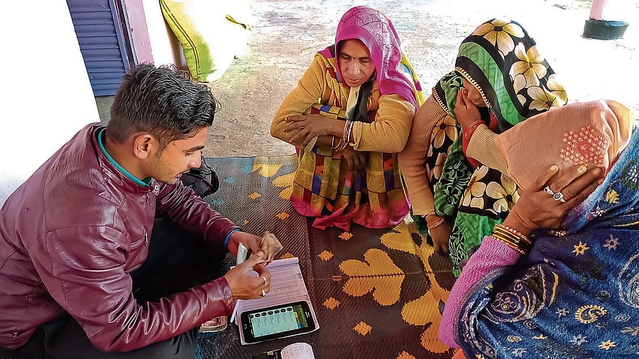 DISTRICT KATNI, INDIA - JANUARY 16, 2020: Indian bank officer collecting installment for Micro finance loan repayment, small group meeting program.