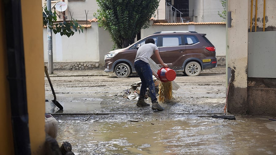 <div class="paragraphs"><p>A resident removes mud from his house after the La Paz River overflowed </p></div>