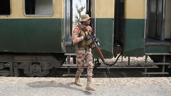 <div class="paragraphs"><p>A Pakistan Army soldier stands guard next to a rescue train, after the attack on a train by separatist militants in Bolan, at the railway station in Mushkaf, Balochistan.</p></div>