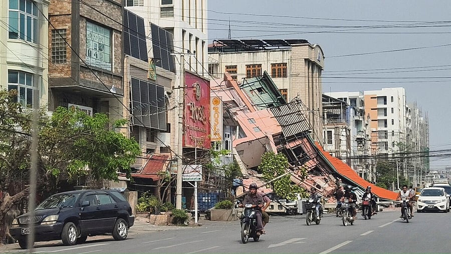 <div class="paragraphs"><p>People ride motorcycles past a damaged building after a strong earthquake struck central Myanmar.</p></div>