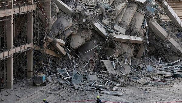 <div class="paragraphs"><p>Rescue personnel walk near a building that collapsed after a strong earthquake struck central Myanmar on Friday, earthquake monitoring services said, which affected Bangkok as well with people pouring out of buildings in the Thai capital in panic after the tremors, in Bangkok.</p></div>
