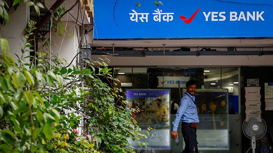 <div class="paragraphs"><p>A private security guard stands outside a branch of Yes Bank.</p></div>