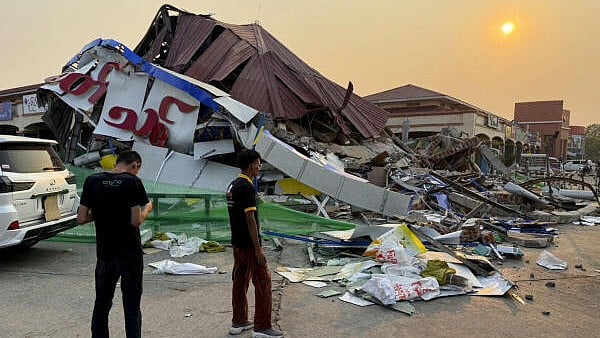 <div class="paragraphs"><p>People stand near a commercial facility which collapsed due to an earthquake, in Naypyitaw</p></div>