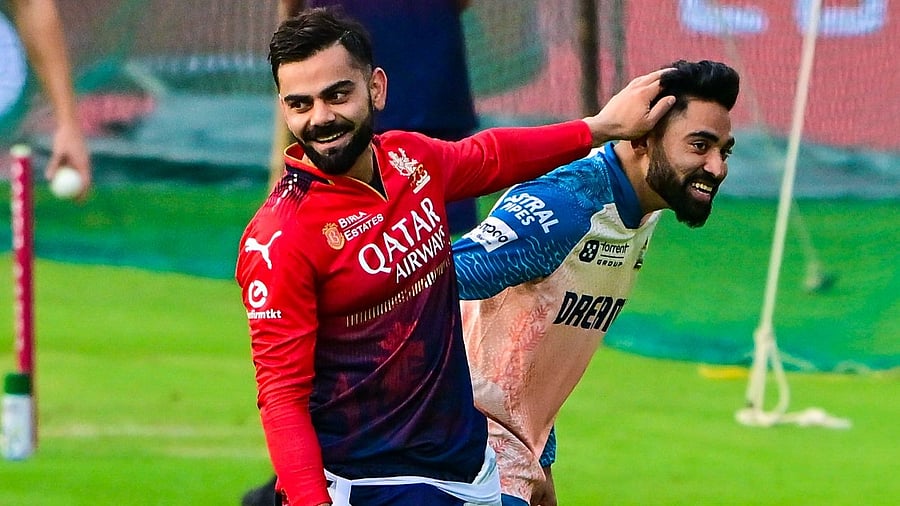 <div class="paragraphs"><p>RCB’s Virat Kohli (left) and Titans’ Mohammed Siraj share a jovial moment during the teams’ practice session at the M Chinnaswamy stadium on Tuesday.  </p></div>