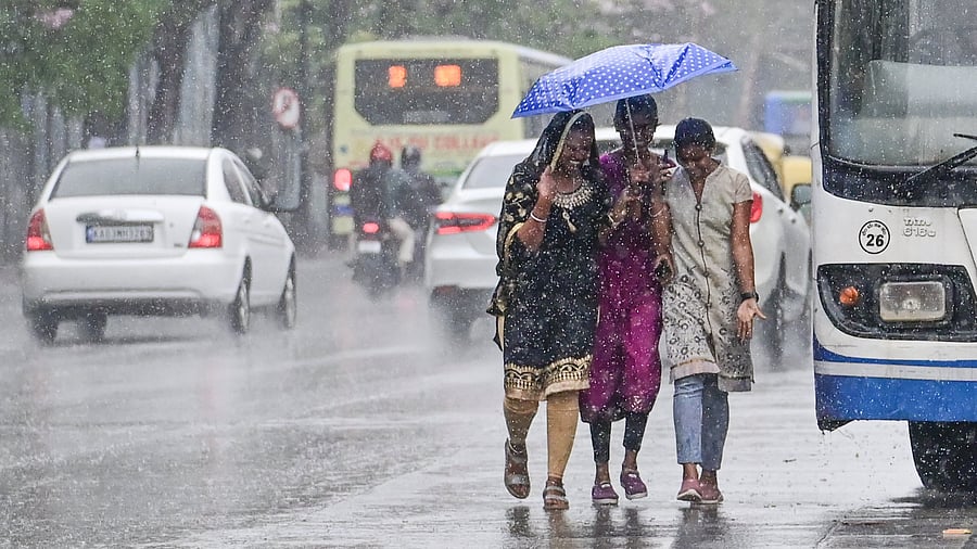 <div class="paragraphs"><p>Girls enjoy the rain at Seshadri Road on Thursday. </p></div>