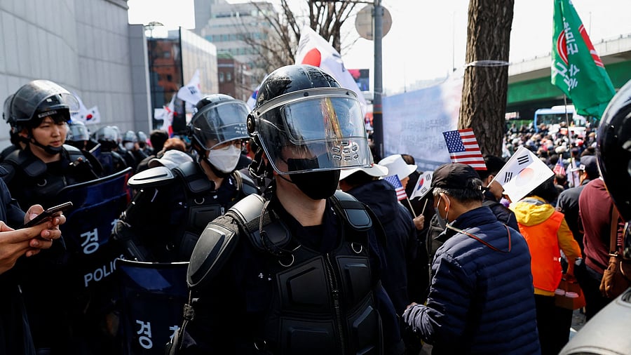 <div class="paragraphs"><p>Members of the police stand guard next to a far-right demonstrators' gathering as they wait for the Constitutional Court ruling on President Yoon Suk Yeol's impeachment, near his residence in Seoul, South Korea</p></div>