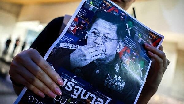<div class="paragraphs"><p>An activist holds a picture of Myanmar's junta leader Min Aung Hlaing during a protest against his visit to Thailand and attending the 6th BIMSTEC Summit in Bangkok.</p></div>