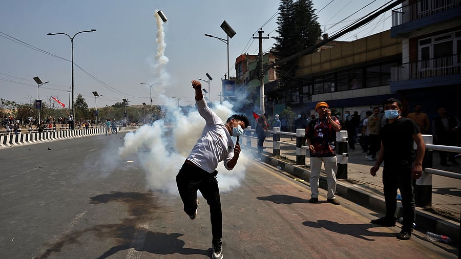 <div class="paragraphs"><p>A pro-monarchist protester throws a gas back towards the riot police personnel during a protest demanding the restoration of Nepal's monarchy, which was abolished in 2008, saying the governments have failed to make any significant changes, in Kathmandu, Nepal, March 28, 2025. </p></div>