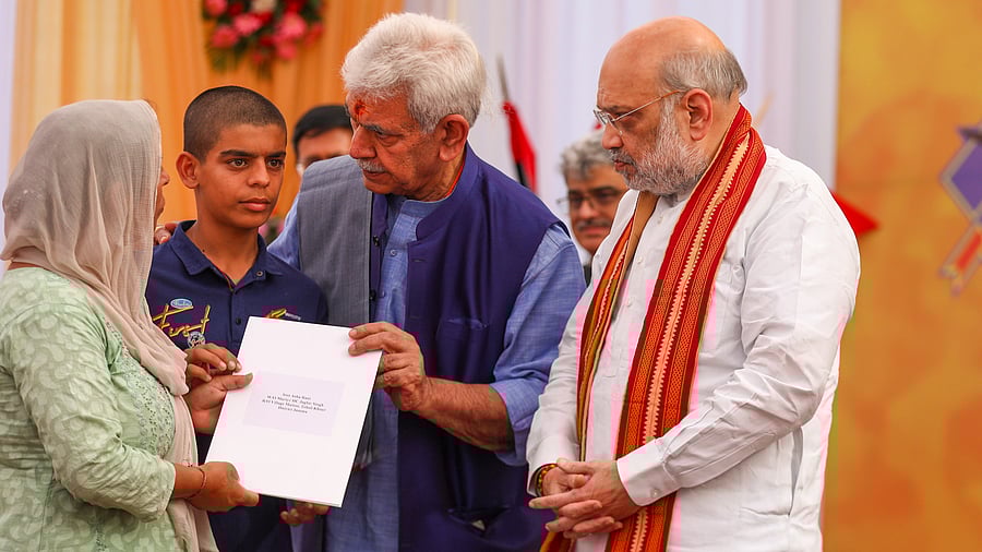 <div class="paragraphs"><p>Union Home Minister Amit Shah and J&amp;K Lt. Governor Manoj Sinha with family members of a martyr during a ceremony organised to honour the martyrs of Jammu and Kashmir Police, at Raj Bhavan, in Jammu, Monday, April 7, 2025.</p></div>