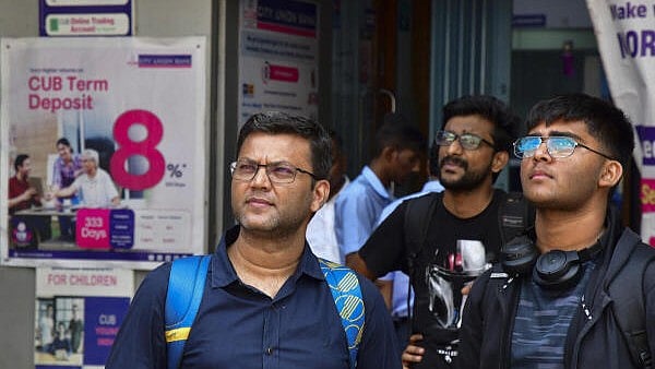 <div class="paragraphs"><p>Commuters watch the stock market updates on a screen outside Bombay Stock Exchange (BSE) building, in Mumbai, Monday, April 7, 2025.</p></div>