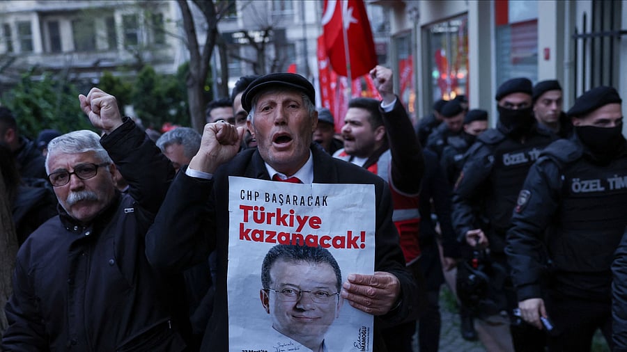 <div class="paragraphs"><p>A man holds a poster with a picture of Istanbul Mayor Ekrem Imamoglu during a rally to protest against the arrest of Imamoglu as part of a corruption investigation, in Istanbul, Turkey.</p></div>