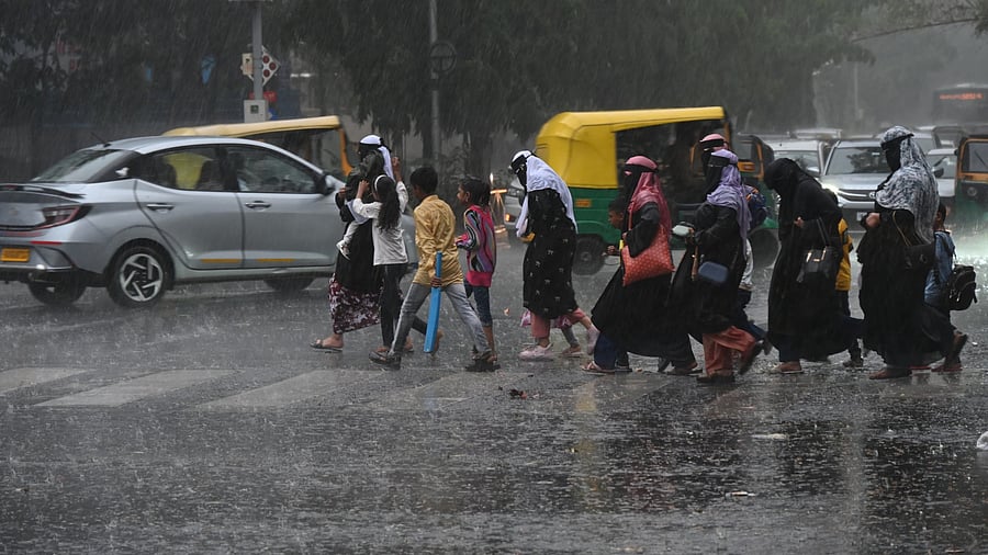 <div class="paragraphs"><p>Women and children run for cover during the downpour on Cubbon Road on Monday. </p></div>