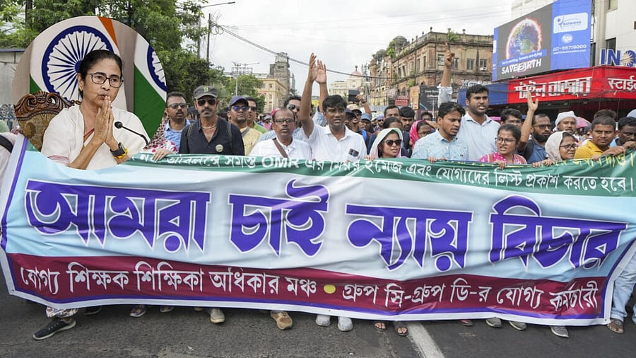 <div class="paragraphs"><p>Protesting teachers seen along with an inset image of Mamata Banerjee</p></div>