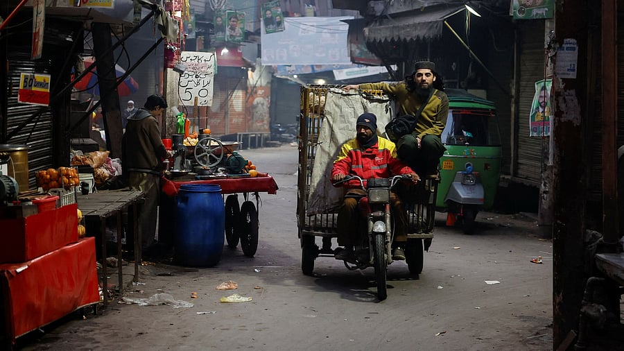 <div class="paragraphs"><p>People commute on a rikshaw while campaign posters are displayed along the street.</p></div>