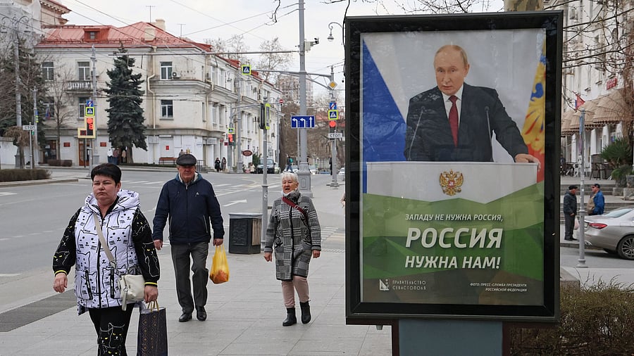 <div class="paragraphs"><p>People walk past a banner depicting Russian President Vladimir Putin in Sevastopol, Crimea March 22, 2025.</p></div>