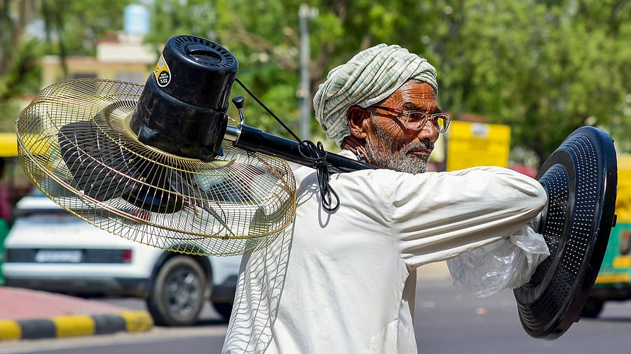<div class="paragraphs"><p> An elderly man carries a pedestal fan on a hot summer day, in Bikaner. </p></div>