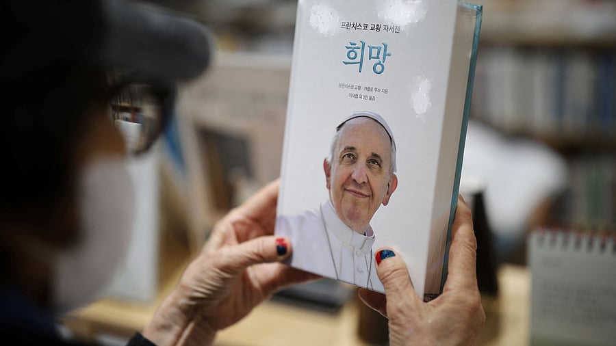 <div class="paragraphs"><p>A Catholic believer looks at a copy of Pope Francis' autobiography book "Hope" at Myeongdong Cathedral, after the death of Pope Francis was announced by the Vatican, in Seoul, South Korea, April 21, 2025. </p></div>