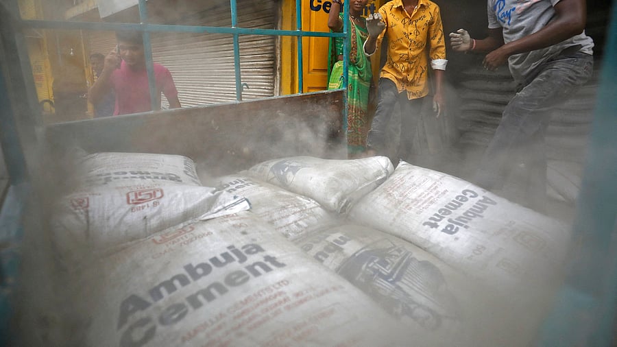 <div class="paragraphs"><p>FILE PHOTO: Workers load Ambuja cement bags into a load carrier to be carried to a construction site in Ahmedabad, India, July 29, 2022. </p></div>