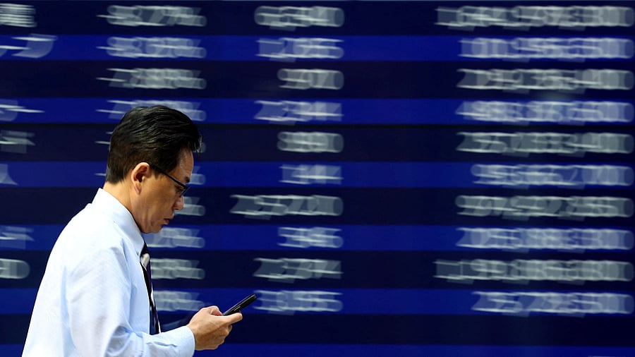 <div class="paragraphs"><p>A man walks past an electronic screen displaying stock quotation board in Tokyo, Japan.</p></div>