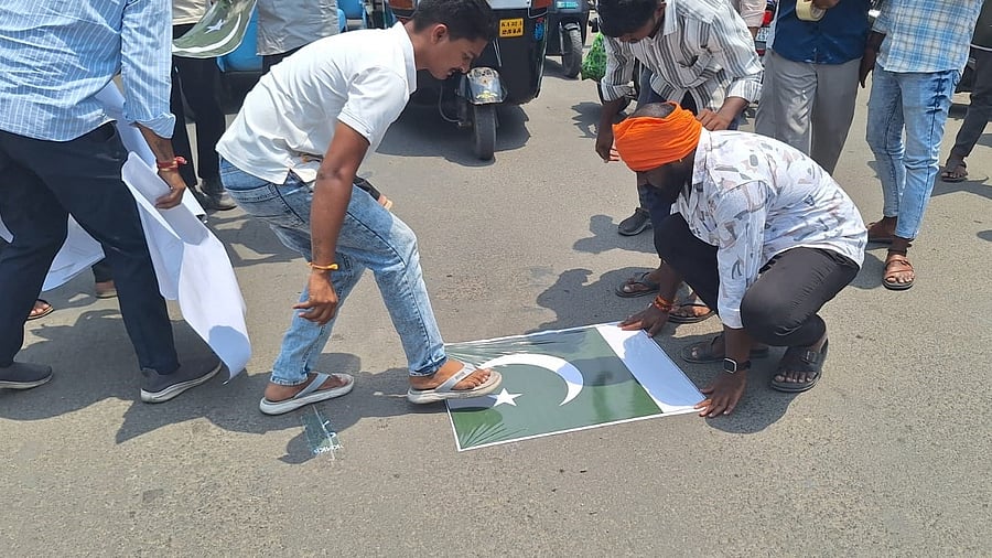 Bajrang Dal activists paste Pakistani flags on a road in Kalaburagi on Friday to protest against the terrorist attack on tourists in Kashmir.