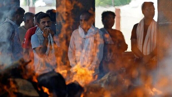 <div class="paragraphs"><p>People react next to the burning pyres of Yatish Parmar and his son Smit Parmar, who were killed in a suspected militant attack near Pahalgam in south Kashmir, at a crematorium in Bhavnagar.</p></div>