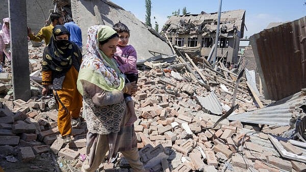 <div class="paragraphs"><p>People near the house of Ahsan Ul Haq Sheikh, a suspect in the Pahalgam terror attack, which was razed in a blast, in Murran area of Pulwama district.</p></div>