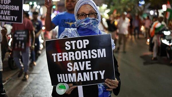 <div class="paragraphs"><p>A woman holds a placard and a candle as she takes part in a solidarity walk condemning a suspected militant attack on tourists near south Kashmir's scenic Pahalgam, in Srinagar, in Kolkata.</p></div>