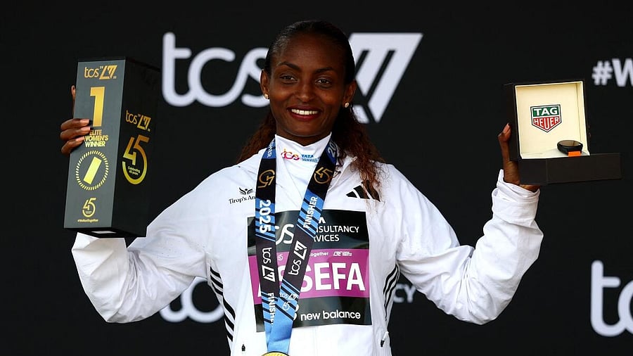 <div class="paragraphs"><p>Ethiopia's Tigst Assefa celebrates on the podium with a trophy after winning the women's elite race.</p></div>
