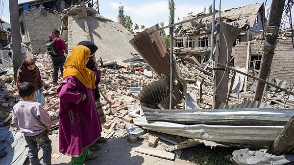 <div class="paragraphs"><p>People stand near the debris of the house of Ahsan Ul Haq Sheikh, a suspect in the Pahalgam terror attack, which was razed in a blast, in Murran area of Pulwama district.</p></div>