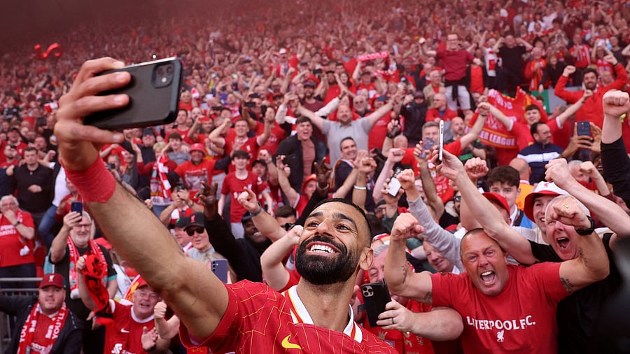 <div class="paragraphs"><p>Liverpool's Mohamed Salah takes a selfie with fans after winning the Premier League.</p></div>
