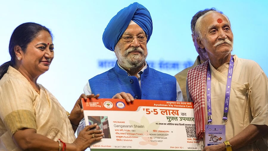 <div class="paragraphs"><p>Union Minister Hardeep Singh Puri (centre) and Delhi Chief Minister Rekha Gupta present the Ayushman Vaya Vandana Card to a beneficiary.&nbsp;</p></div>